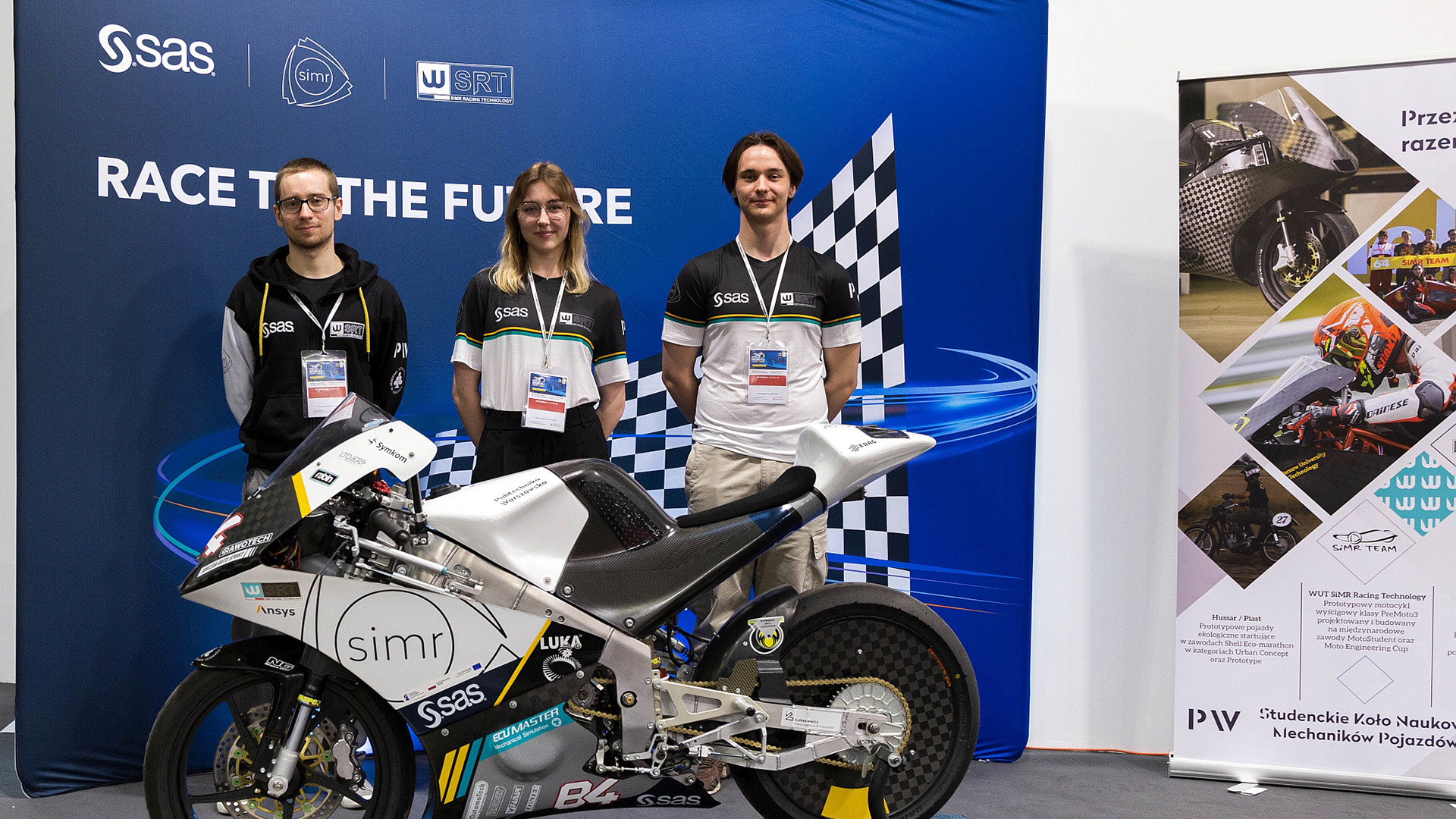 Na zdjęciu motocykl oraz troje członków zespołu