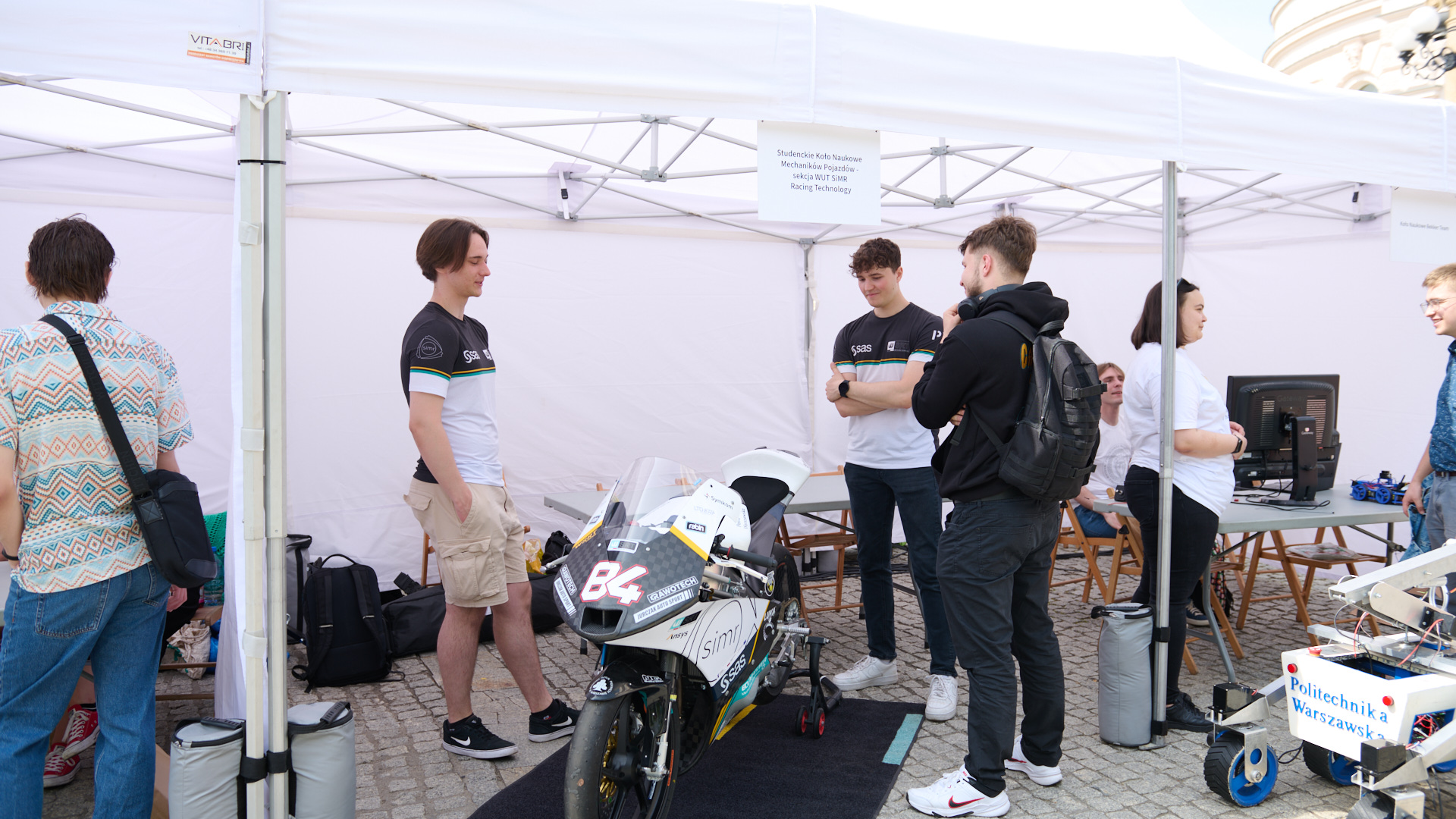 Na zdjęciu studenci z kół naukowych i ich projekty: motocykl i łazik