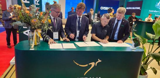 Na zdjęciu czterej mężczyźni przy stole podpisują porozumienia o współpracy