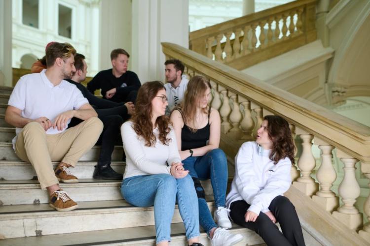 Zdjęcie studentów siedzących na schodach w Gmachu Głównym Politechniki Warszawskiej