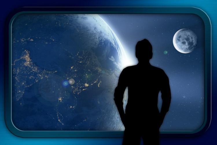 Zdjęcie człowieka oglądającego przestrzeń za oknem statku kosmicznego