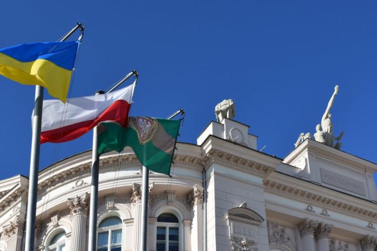 Zdjęcie Gmachu Głównego Politechniki Warszawskiej i masztów z flagami Ukrainy, Polski i PW