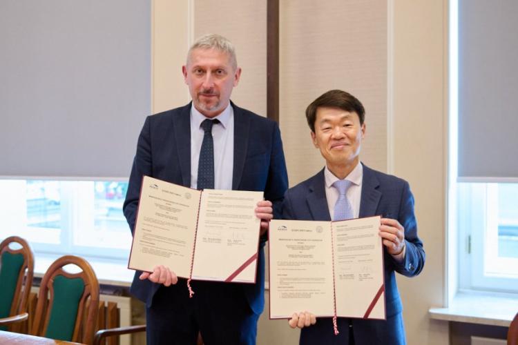 Prorektor PW ds. Nauki prof. Mariusz Malinowski oraz Prezydent KATECH Seung-Sik NA trzymający podpisane umowy