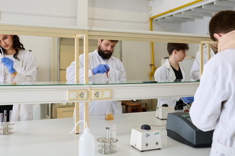 Na zdjęciu kilka osób pracujących w laboratorium chemicznym 