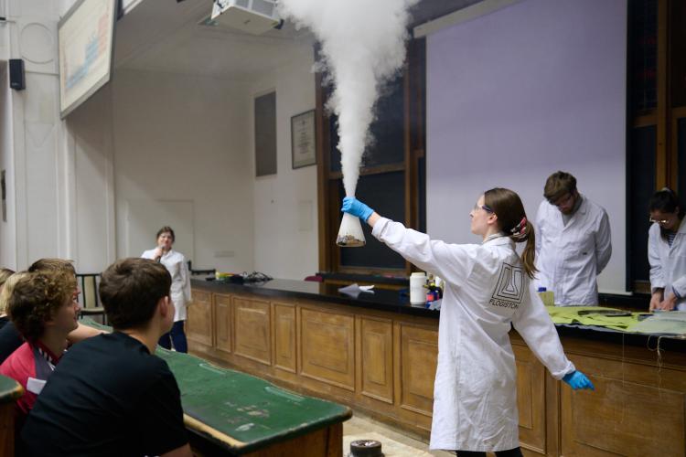 Na zdjęciu studenci pokazujący dymiącą kolbę 