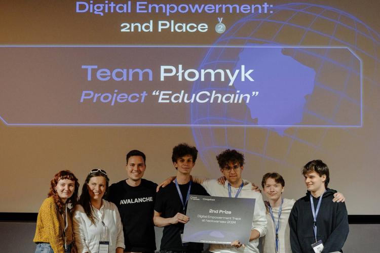 Na zdjęciu siedem osób, w tym czworo studentów PW z czekiem za zajęcie drugiego miejsca w hackathonie