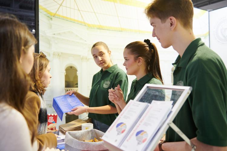 Na zdjęciu grupa osób przy stanowisku Politechniki Warszawskiej na Międzynarodowym Salonie Edukacyjnym 2025