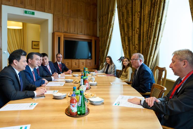 Na zdjęciu grupa osób siedzących przy stole - przedstawiciele przedstawicieli Politechniki Warszawskiej i Uzbekistanu