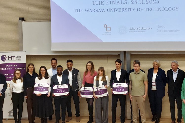 Zdjęcie przedstawia laureatów i jurorów konkursu Three Minute Thesis na Politechnice Warszawskiej stojących razem na scenie. Laureaci trzymają tablice z przyznanymi nagrodami.