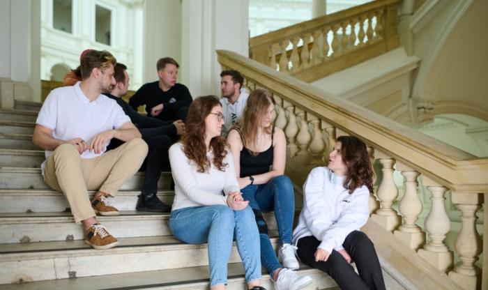 Zdjęcie studentów siedzących na schodach w Gmachu Głównym Politechniki Warszawskiej