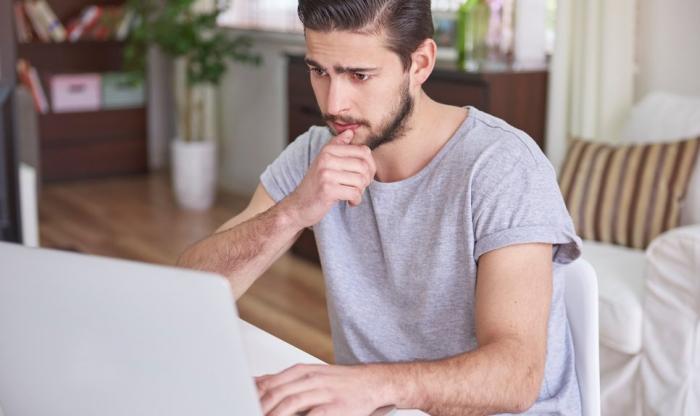 Zdjęcie mężczyzny siedzącego przed ekranem laptopa