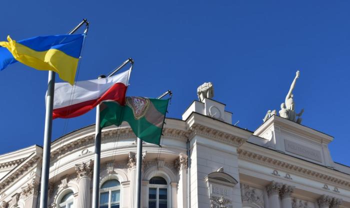 Zdjęcie Gmachu Głównego Politechniki Warszawskiej i masztów z flagami Ukrainy, Polski i PW