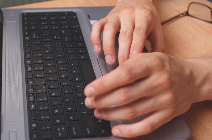 Zdjęcie ludzkich rąk i klawiatury komputera