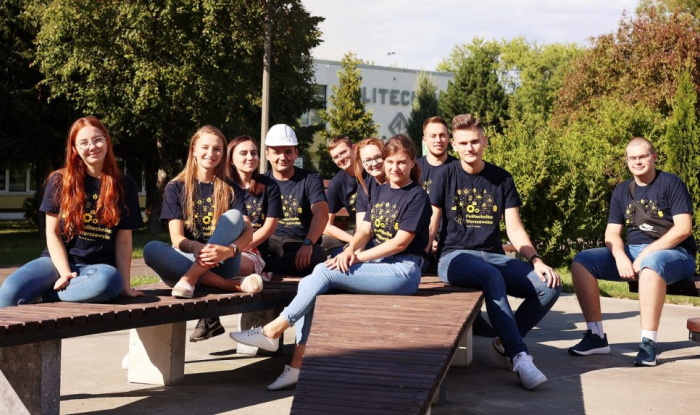Zdjęcie grupy studentów, którzy siedzą przed Gmachem Filii PW w Płocku
