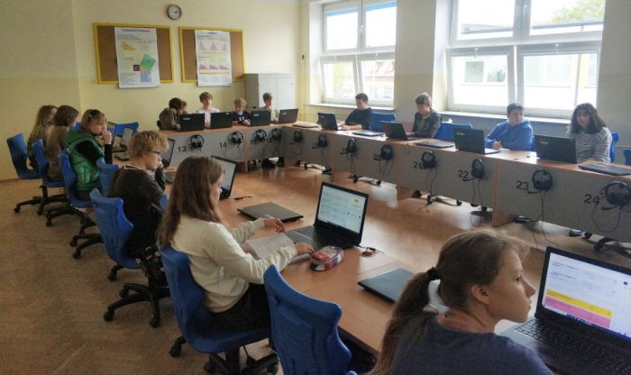 Zdjęcie uczniów siedzących przy komputerach i korzystających z systemu zeszyt.online