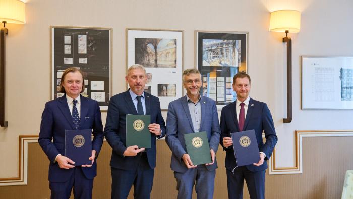 Na zdjęciu czterej mężczyźni pozujący z dyplomami