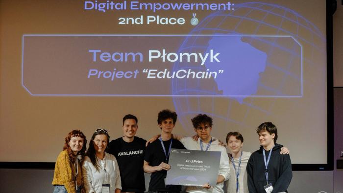 Na zdjęciu siedem osób, w tym czworo studentów PW z czekiem za zajęcie drugiego miejsca w hackathonie