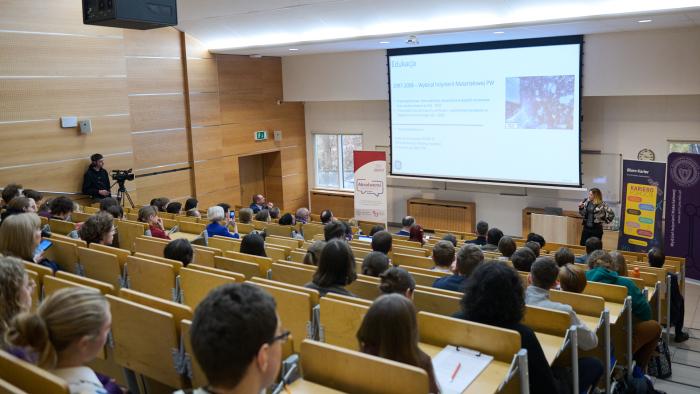 Na zdjęciu sala wypełniona ludźmi podczas debaty „Zmaterializuj swój sukces – inżynieria materiałowa odpowiedzią na wyzwania współczesnego świata”
