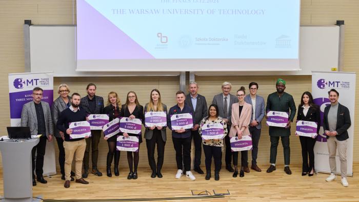 Na zdjęciu dziesięcioro finalistów konkursu 3MT na Politechnice Warszawskiej, jurorzy oraz prowadzący. Wszyscy stoją na scenie