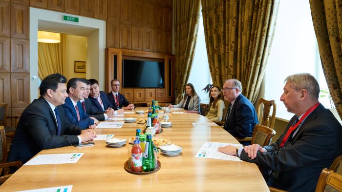 Na zdjęciu grupa osób siedzących przy stole - przedstawiciele przedstawicieli Politechniki Warszawskiej i Uzbekistanu