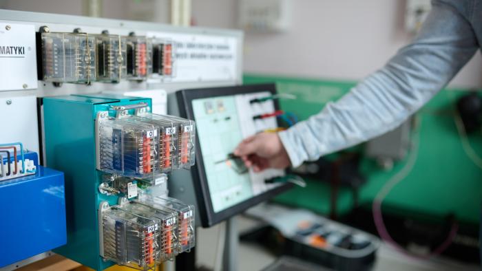 Na zdjęciu ręka, komputer i urządzenia z laboratorium
