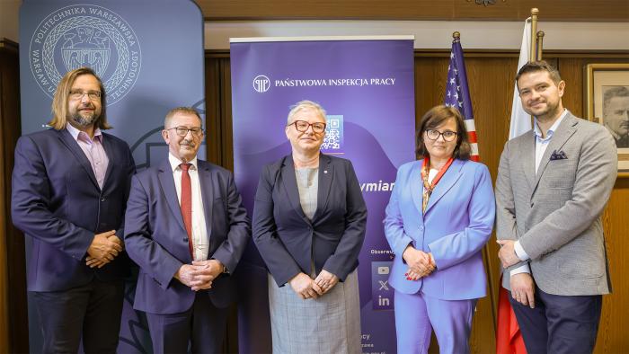 Na zdjęciu pięć osób (trzech mężczyzn i dwie kobiety) stojących na tle ścianek