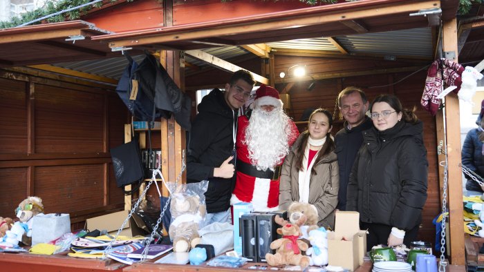 Na zdjęciu grupa osób w kiemaszowym domku 