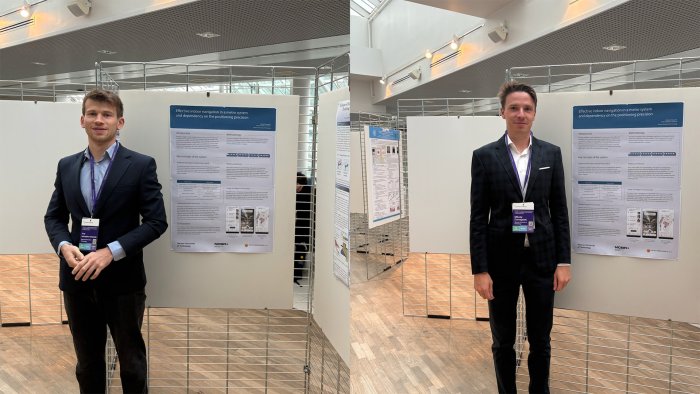 Na zdjęciu Jerzy Jastrzębiec-Jankowski i Mikołaj Domagalski stoją na tle posterów na International Conference on Indoor Positioning and Indoor Navigation w Finlandii