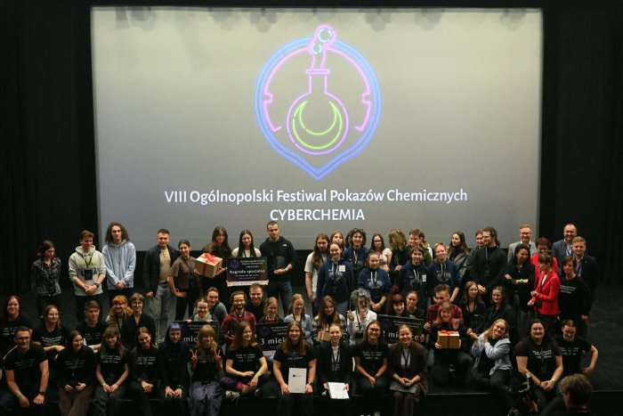 Grupa laureatów konkursu stojąca na scenie na tle logotypu VIII&nbsp;Ogólnopolskiego Festiwalu Pokazów Chemicznych.