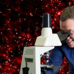 Grafika przedstawiająca prof. Macieja Trusiaka spoglądającego przez mikroskop, w tle znajdują się komórki w dużym przybliżeniu