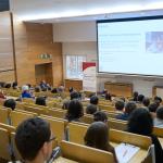 Na zdjęciu sala wypełniona ludźmi podczas debaty „Zmaterializuj swój sukces – inżynieria materiałowa odpowiedzią na wyzwania współczesnego świata”