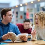 Na zdjęciu troje studentów siedzących w Bibliotece Politechnice Warszawskiej