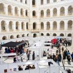 Na zdjęciu stanowiska kół naukowych oraz grupa ludzi w Dużej Auli Gmachu Głównego