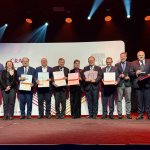 Zdjęcie grupowe wykonane na scenie podczas uroczystości wręczenia nagród Elsevier Research Impact Leaders Awards 2025. Przedstawia kilkanaście osób stojących w rzędzie, część z nich trzyma dyplomy i statuetki.