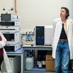 Na zdjęciu pięcioro studentów ubranych w białe fartuchy laboratoryjne w laboratorium chemicznym